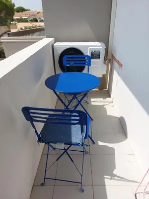 a blue table and a chair on a balcony at Vagues et Vignes Gruissan Corbières in Gruissan