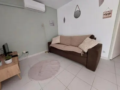 a living room with a brown couch and a rug at Vagues et Vignes Gruissan Corbières in Gruissan