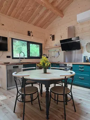 a kitchen with a table and chairs in a room at Chalet Lac de la Raviège la Laurinette SPA in Anglès