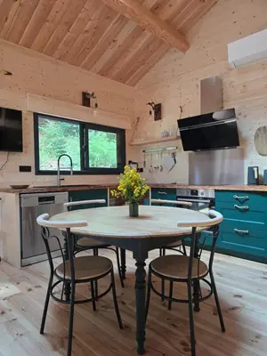 a kitchen with a table and chairs in a room at Chalet Lac de la Raviège la Laurinette SPA in Anglès