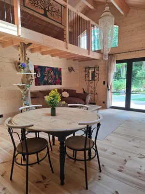 a dining room with a table and chairs at Chalet Lac de la Raviège la Laurinette SPA in Anglès