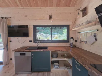 a kitchen with a sink and a window in a cabin at Chalet Lac de la Raviège la Laurinette SPA in Anglès