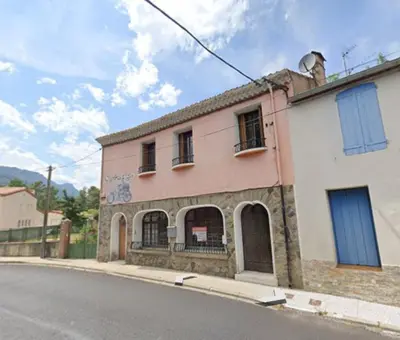 a pink building on the side of a street at Hôtel routard in Caudiès-de-Fenouillèdes