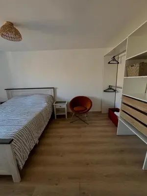 a bedroom with a bed and a chair in it at Au cœur de l'histoire in Narbonne