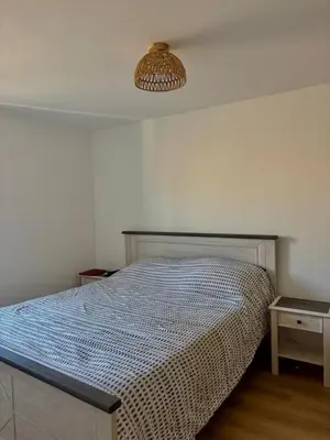 a bedroom with a bed and a light fixture at Au cœur de l'histoire in Narbonne