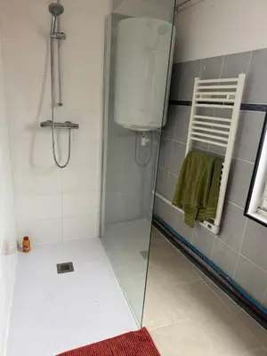 a shower with a glass door in a bathroom at Au cœur de l'histoire in Narbonne