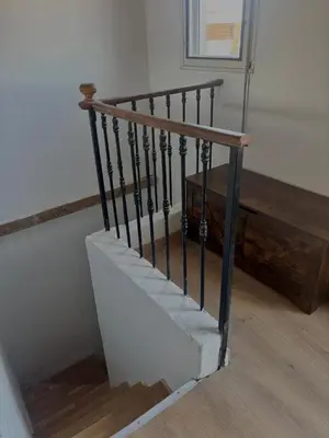 a staircase with black railings next to a wooden bench at Au cœur de l'histoire in Narbonne