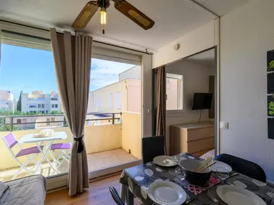 a living room with a table and a balcony at Apartment Gruissan Port-5 by Interhome in Gruissan