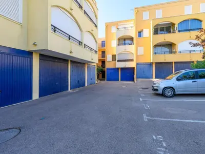 a car parked in a parking lot next to a building at Apartment Gruissan Port-5 by Interhome in Gruissan
