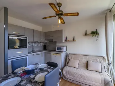 a kitchen and living room with a table and a couch at Apartment Gruissan Port-5 by Interhome in Gruissan