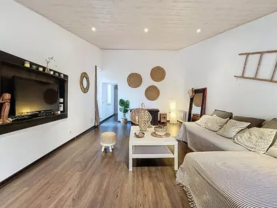 a living room with a couch and a table at L'Espert - Appartement avec Terrasse in Gruissan