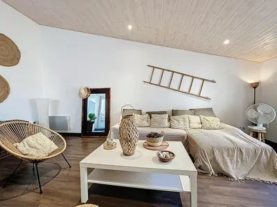 a bedroom with a bed and a table and a chair at L'Espert - Appartement avec Terrasse in Gruissan