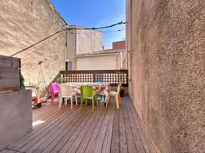 a table and chairs sitting on a wooden deck at L'Espert - Appartement avec Terrasse in Gruissan