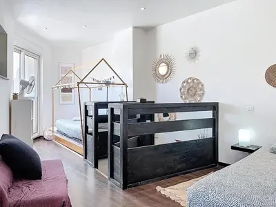 a room with a bedroom with a bed and a mirror at L'Espert - Appartement avec Terrasse in Gruissan