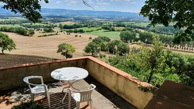 a table and two chairs on a balcony with a view at Le Refuge du Tarn - Grand Jardin in Puylaurens