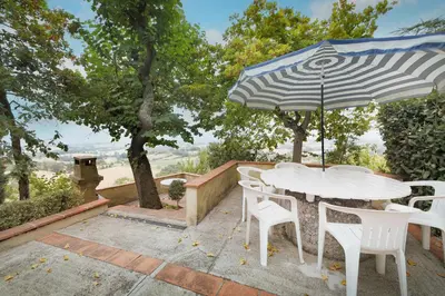 a white table and chairs with an umbrella at Le Refuge du Tarn - Grand Jardin in Puylaurens