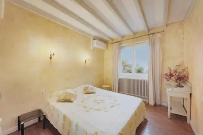 a bedroom with a large bed and a window at Le Refuge du Tarn - Grand Jardin in Puylaurens