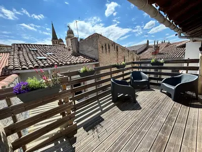 a wooden deck with chairs and flowers on a roof at La Dolce Vista et sa terrasse privée avec vue in Revel