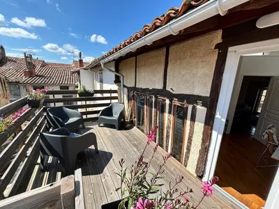a wooden deck with two chairs on a house at La Dolce Vista et sa terrasse privée avec vue in Revel
