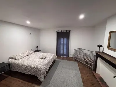 a bedroom with a bed and a crib in it at La Dolce Vista et sa terrasse privée avec vue in Revel
