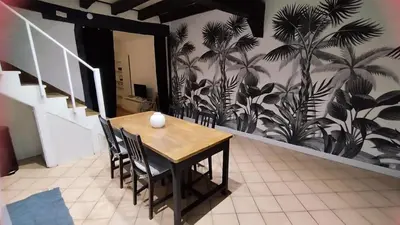 a table and chairs in a room with a wall at La Dolce Vista et sa terrasse privée avec vue in Revel