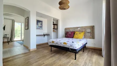 a bedroom with a bed with colorful pillows on it at Appartement en maison d'hôtes in Badens