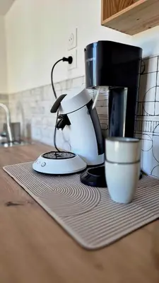 a coffee maker and a cup on a kitchen counter at Appartement en maison d'hôtes in Badens