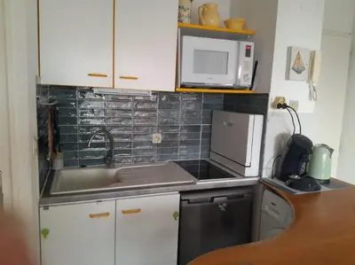 a small kitchen with a sink and a microwave at Joli appartement climatisé résidence avec piscine et plage du Grazel à 180m in Gruissan