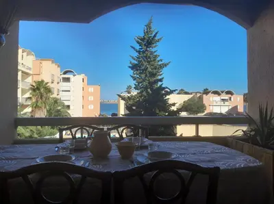 a table with a christmas tree on a balcony at Joli appartement climatisé résidence avec piscine et plage du Grazel à 180m in Gruissan