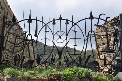 a iron fence with arrows on it in a field at Mas Les Albas in Felluns