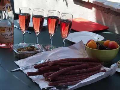 a table topped with glasses of champagne and sausages at Mas Les Albas in Felluns