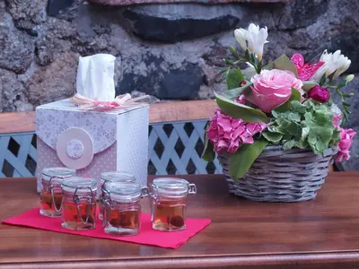 a table with a vase of flowers and a basket of roses at Mas Les Albas in Felluns