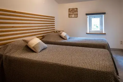 two beds in a bedroom with a large headboard at Mas Les Albas in Felluns