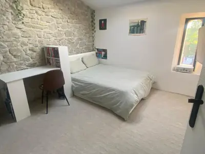 a small bedroom with a bed and a desk at villa proche carcassonne avec piscine chauffée intérieur in Villesequelande