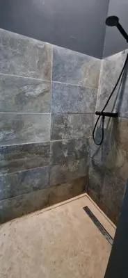 a bathroom with a shower with a stone wall at villa proche carcassonne avec piscine chauffée intérieur in Villesequelande
