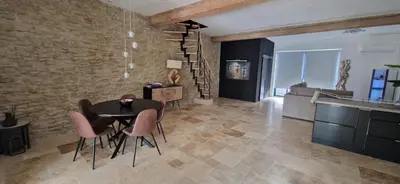 a dining room with a table and chairs in a room at villa proche carcassonne avec piscine chauffée intérieur in Villesequelande