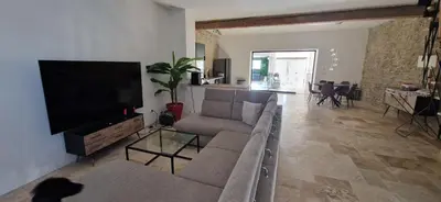 a living room with a couch and a flat screen tv at villa proche carcassonne avec piscine chauffée intérieur in Villesequelande