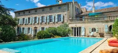 a large swimming pool in front of a building at Maison Barbaira