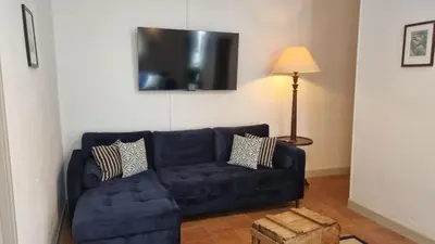 a living room with a blue couch and a lamp at Maison Barbaira