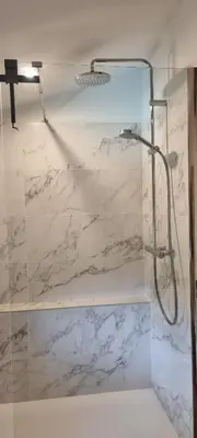 a bathroom with a shower with white marble at Maison Barbaira