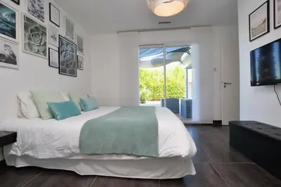 a bedroom with a large bed and a television at Villa d'architecte avec piscine chauffée, 4 chambres, à 30 mn Gruissan plage in Sallèles-dʼAude