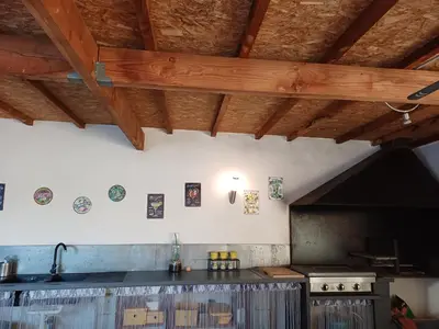 a kitchen with a sink and a stove and wooden ceilings at Villa d'architecte avec piscine chauffée, 4 chambres, à 30 mn Gruissan plage in Sallèles-dʼAude
