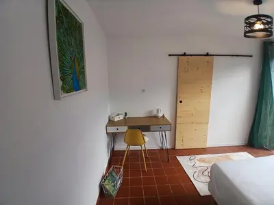 a bedroom with a desk and a yellow chair at Appartement Atypique Corbières in Montséret