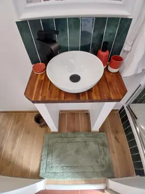 a bathroom with a white sink on a wooden table at Appartement Atypique Corbières in Montséret