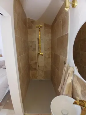 a bathroom with a shower with a toilet and a sink at Appartement Atypique Corbières in Montséret
