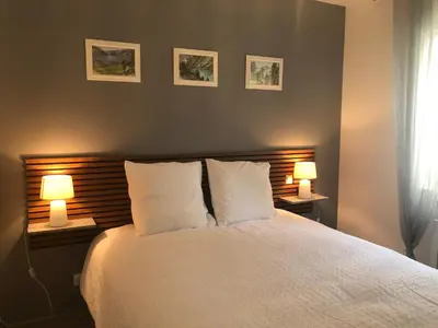 a bedroom with a white bed with two lamps at Maison d'hôtes à Castres-Saïx in Saix