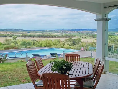 a patio with a table and chairs and a pool at B&B-Les Balcons de Maragon in Carcassonne