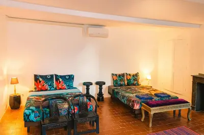 a room with two beds and a bench in it at Les 2 Petits Lapins in Luc-sur-Orbieu