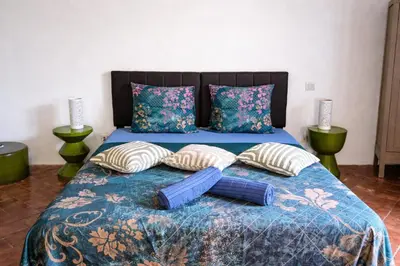 a bed with a blue comforter and pillows at Les 2 Petits Lapins in Luc-sur-Orbieu