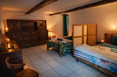 a bedroom with a bed and a tv and a table at Les 2 Petits Lapins in Luc-sur-Orbieu